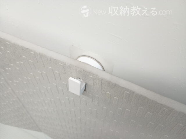 IPシステム「レバー式吸盤スプレーフック」（JAN：4580004043341）でユニットバスの壁面にバスマットを掛けた状態